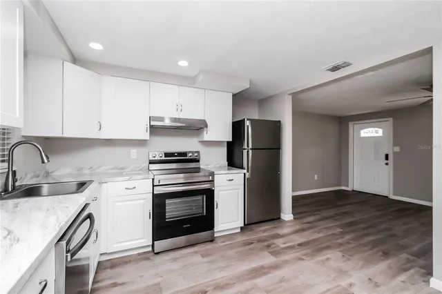 a kitchen with a sink cabinets and stainless steel appliances