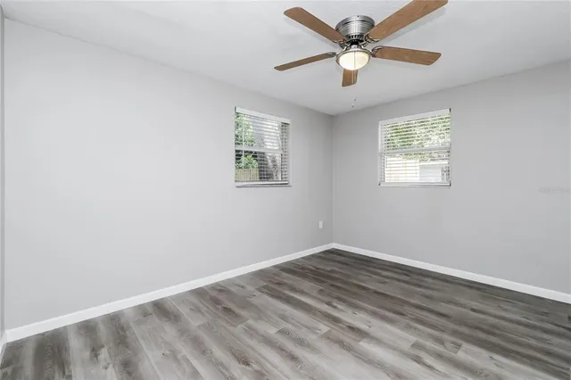 an empty room with a window and a fan