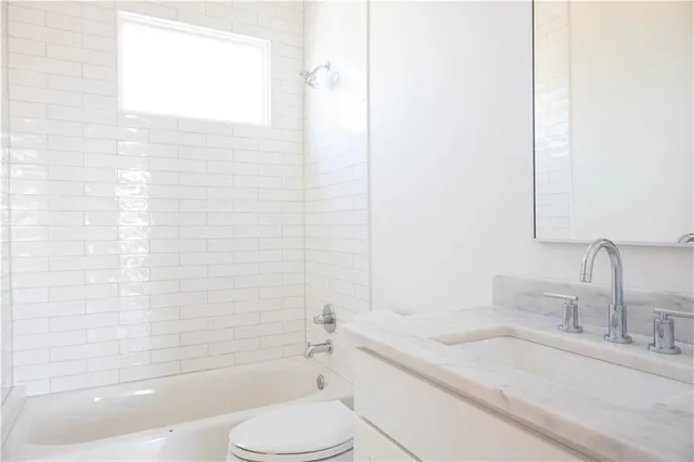 a kitchen with granite countertop a stove and a white cabinets