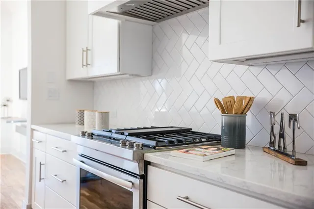 a open kitchen with stainless steel appliances a sink stove and wooden floor