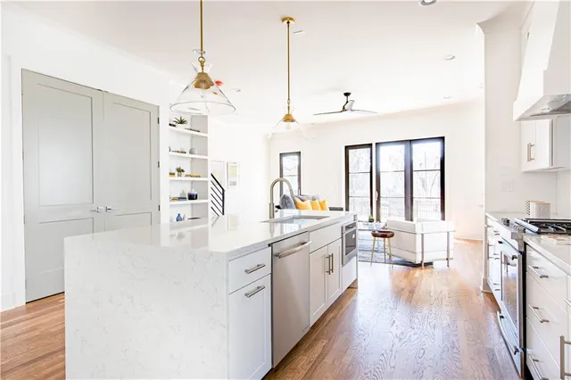 a kitchen with stainless steel appliances granite countertop a sink a refrigerator and a stove