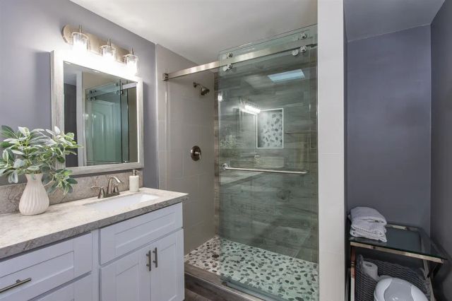 a bathroom with a shower sink and mirror