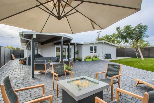 a view of a patio with table and chairs under an umbrella