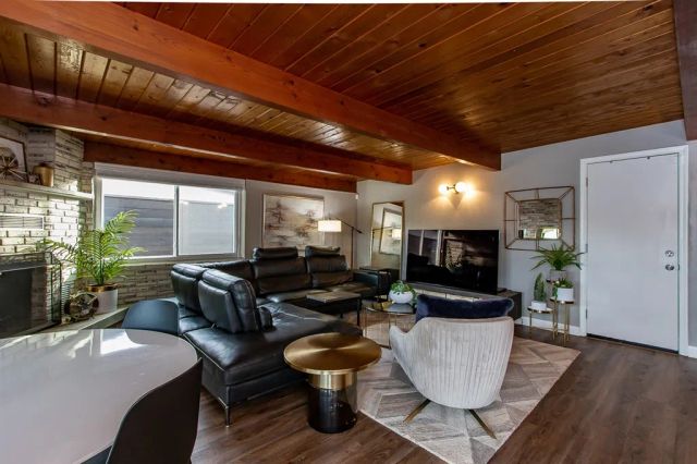 a living room with fireplace furniture and a large window