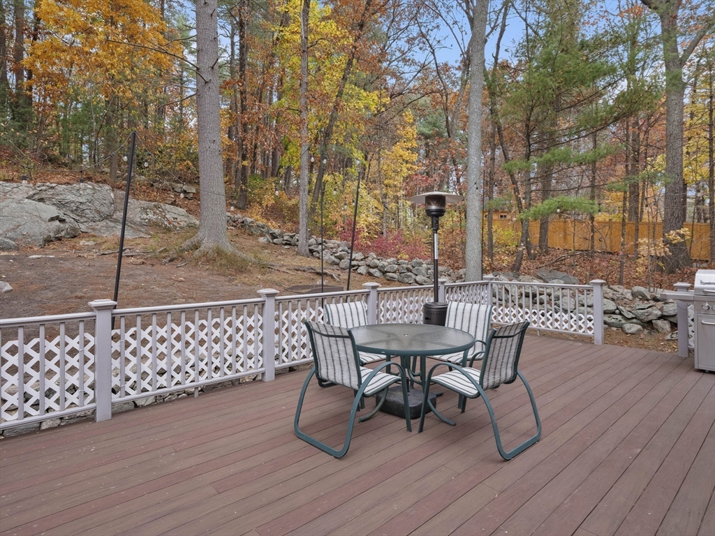 38 Mohawk Drive Acton, MA 01720 - Photo 29 of 35 a view of a roof deck with table and chairs with wooden floor and fence