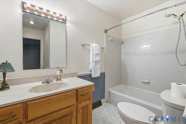 a bathroom with a sink a toilet a mirror a bathtub and shower