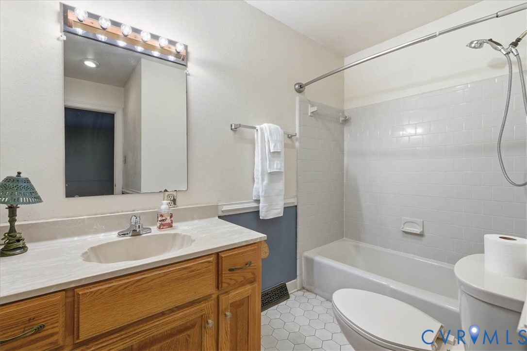 503 Prince George Avenue Hopewell, VA 23860 - Photo 21 of 25 a bathroom with a sink a toilet a mirror a bathtub and shower