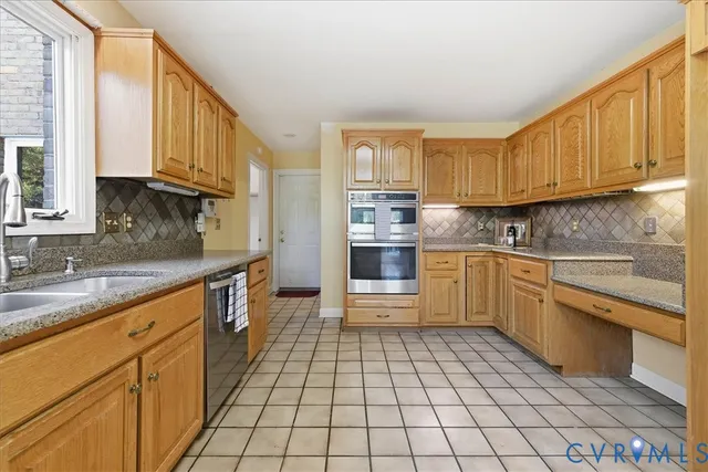 a kitchen with granite countertop a sink a stove top oven and cabinets
