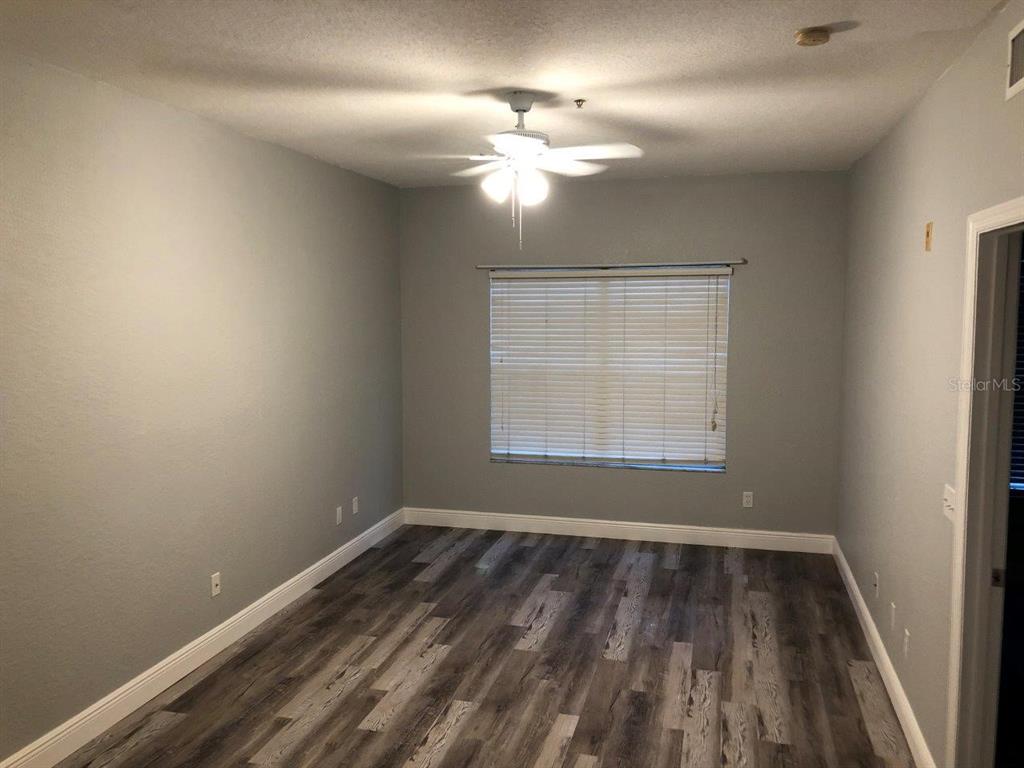 831 Camargo Way, Unit 302 Altamonte Springs, FL 32714 - Photo 11 of 28 an empty room with wooden floor fan and window