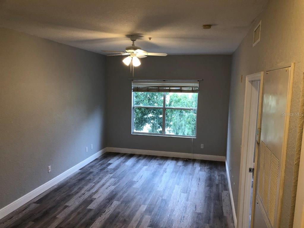 831 Camargo Way, Unit 302 Altamonte Springs, FL 32714 - Photo 12 of 28 an empty room with wooden floor fan and windows