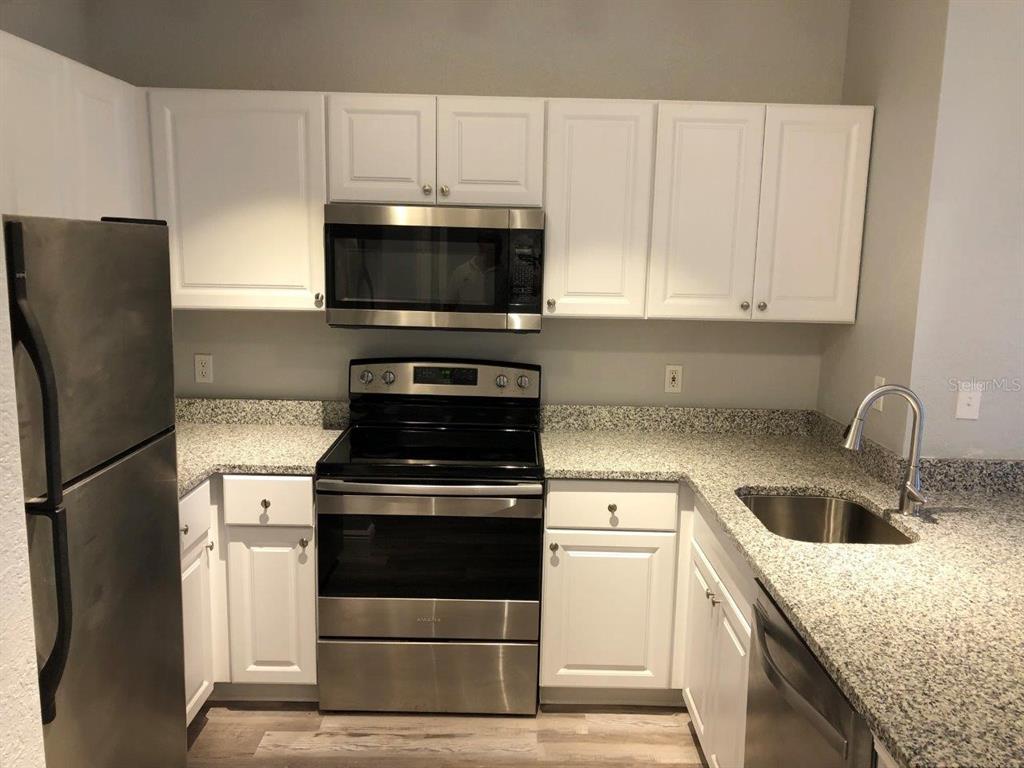 831 Camargo Way, Unit 302 Altamonte Springs, FL 32714 - Photo 6 of 28 a kitchen with a stove microwave and refrigerator