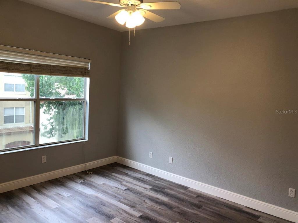 831 Camargo Way, Unit 302 Altamonte Springs, FL 32714 - Photo 8 of 28 a view of an empty room with wooden floor and a window