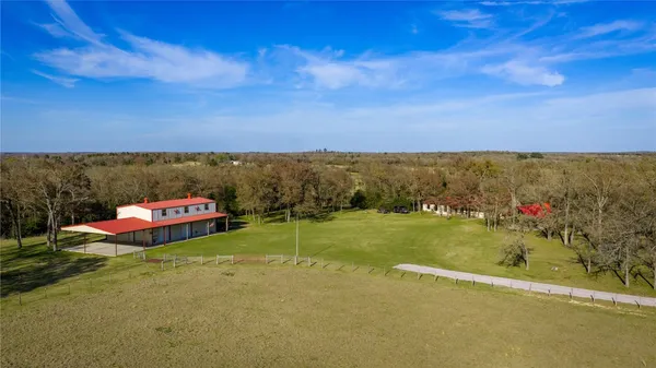 a view of a house with backyard and trees