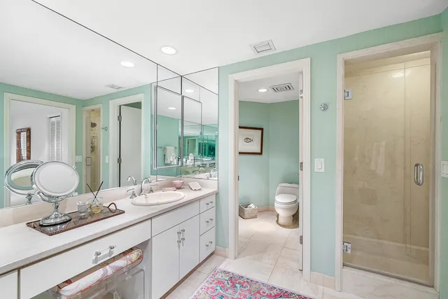 a bathroom with a granite countertop sink a toilet and a mirror