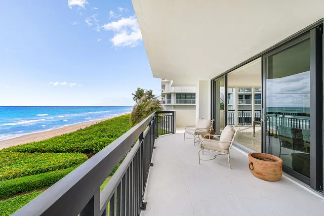a balcony with chairs and ocean view