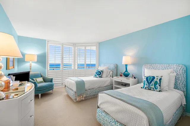 a bed room with two beds and a large window