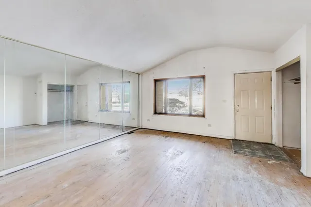 an empty room with window and wooden floor