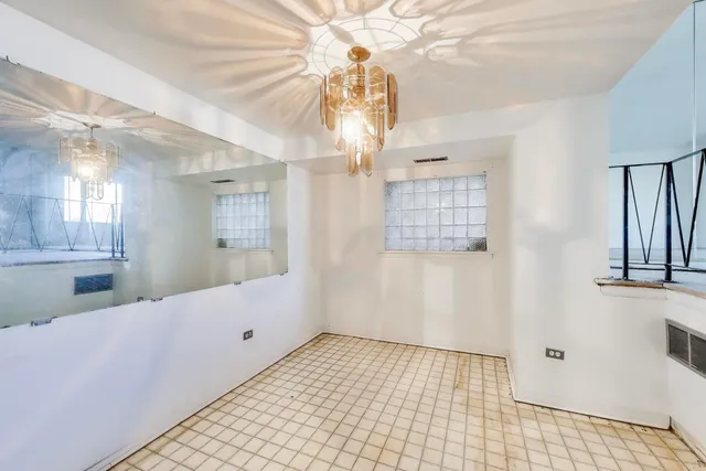 a view of a hallway with windows and chandelier