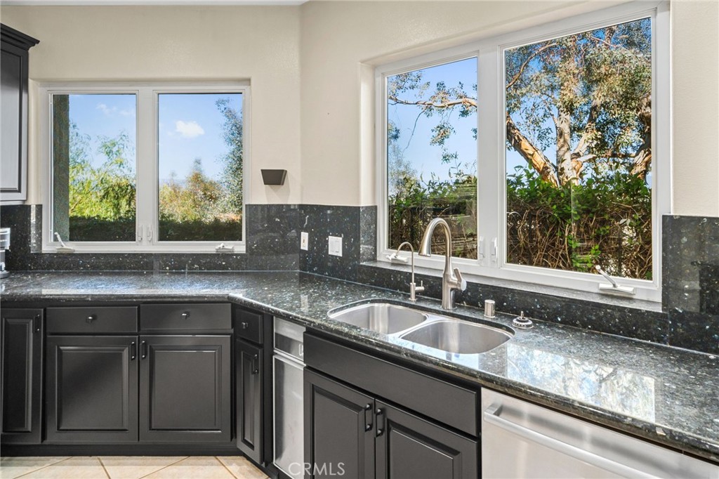 24806 Carlos Place Newhall, CA 91321 - Photo 14 of 56 a kitchen with granite countertop a sink and a window