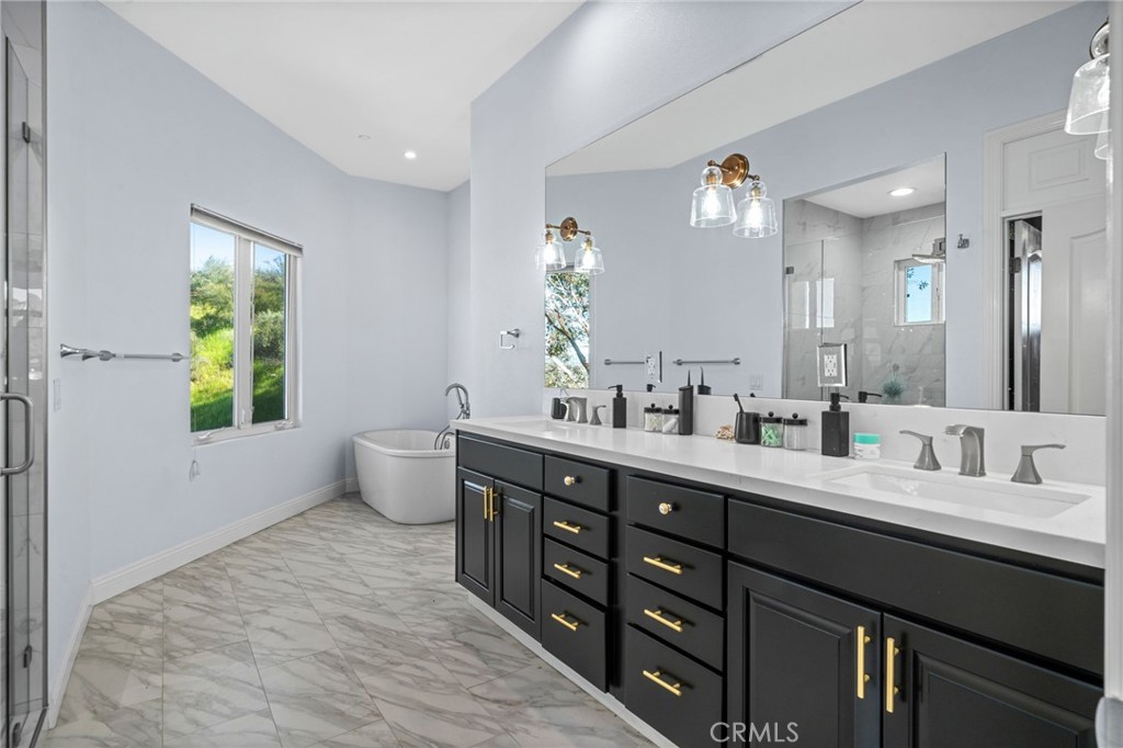 24806 Carlos Place Newhall, CA 91321 - Photo 23 of 56 a bathroom with double vanity sink a toilet and a window