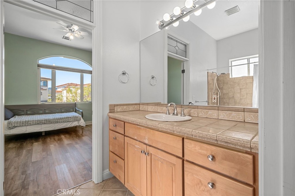 24806 Carlos Place Newhall, CA 91321 - Photo 33 of 56 a en suite bathroom with a granite countertop sink and a mirror