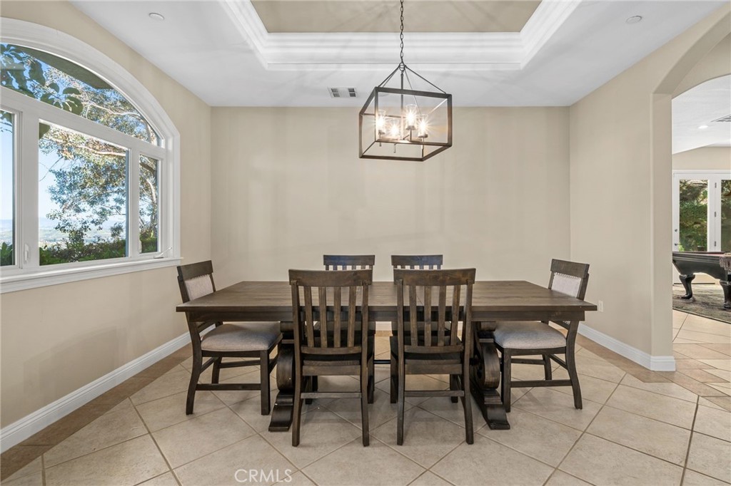 24806 Carlos Place Newhall, CA 91321 - Photo 9 of 56 a view of a dining room with furniture a chandelier and a window