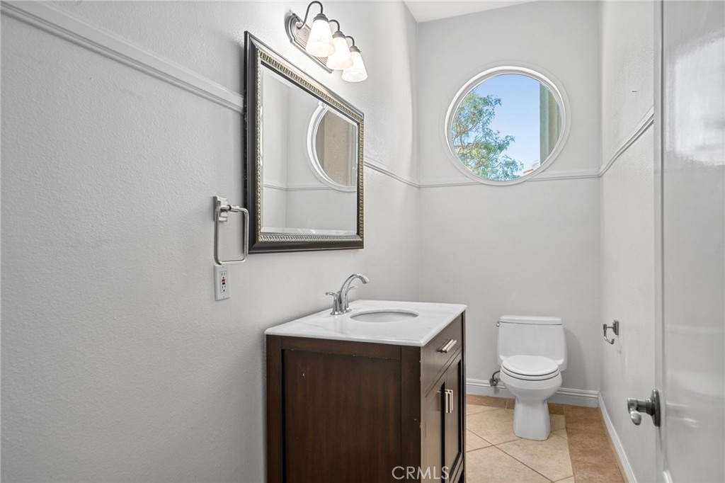 24806 Carlos Place Newhall, CA 91321 - Photo 10 of 56 a bathroom with a toilet a sink and mirror