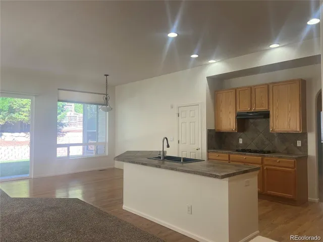 a kitchen with granite countertop a sink and a stove top oven