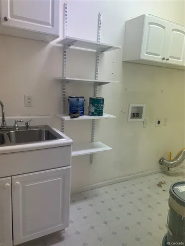 a utility room with a sink a vanity and toilet