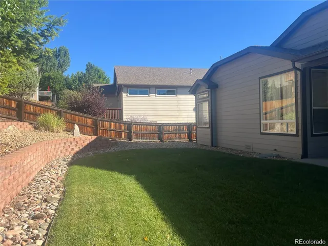a view of house with backyard and garden