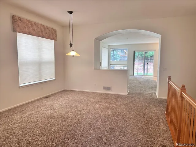 a view of an empty room with window and cabinet