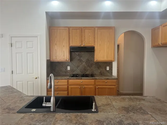 a kitchen with stainless steel appliances granite countertop a refrigerator and a stove top oven