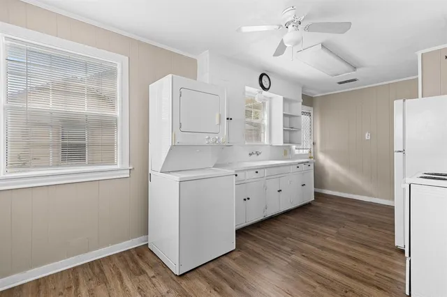 a large white kitchen with a refrigerator a sink dishwasher and a fireplace