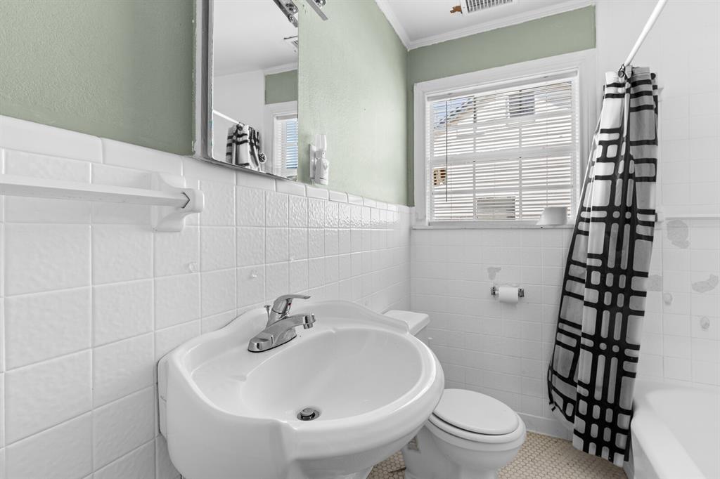 1212 Lewis Street Waco, TX 76705 - Photo 9 of 12 a white toilet sitting next to a bathroom sink