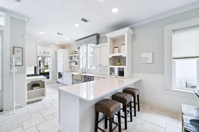 a kitchen with white cabinets and sink