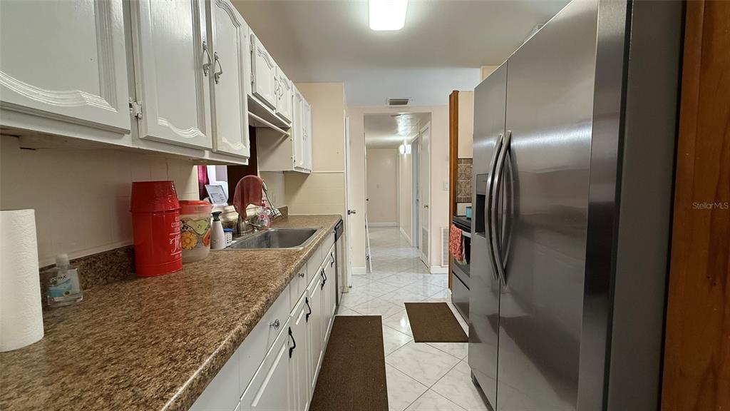 5754 9th Street Zephyrhills, FL 33542 - Photo 12 of 25 a kitchen with stainless steel appliances granite countertop a refrigerator a oven and white cabinets