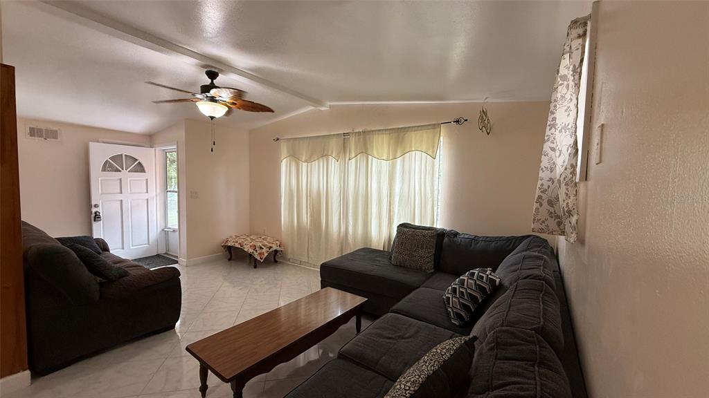 5754 9th Street Zephyrhills, FL 33542 - Photo 2 of 25 a living room with furniture and a window