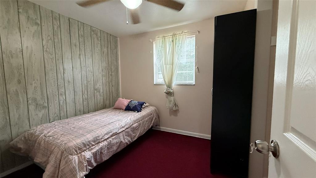 5754 9th Street Zephyrhills, FL 33542 - Photo 7 of 25 a bed sitting in a bedroom next to a window