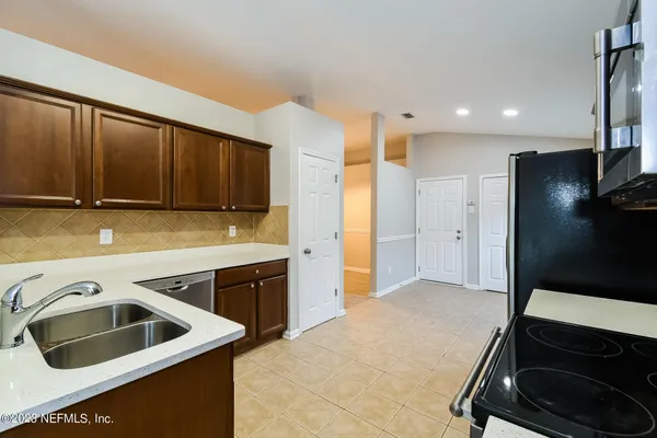 a kitchen with a sink a refrigerator and cabinets
