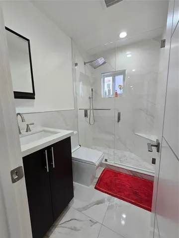 a bathroom with a sink vanity and a toilet
