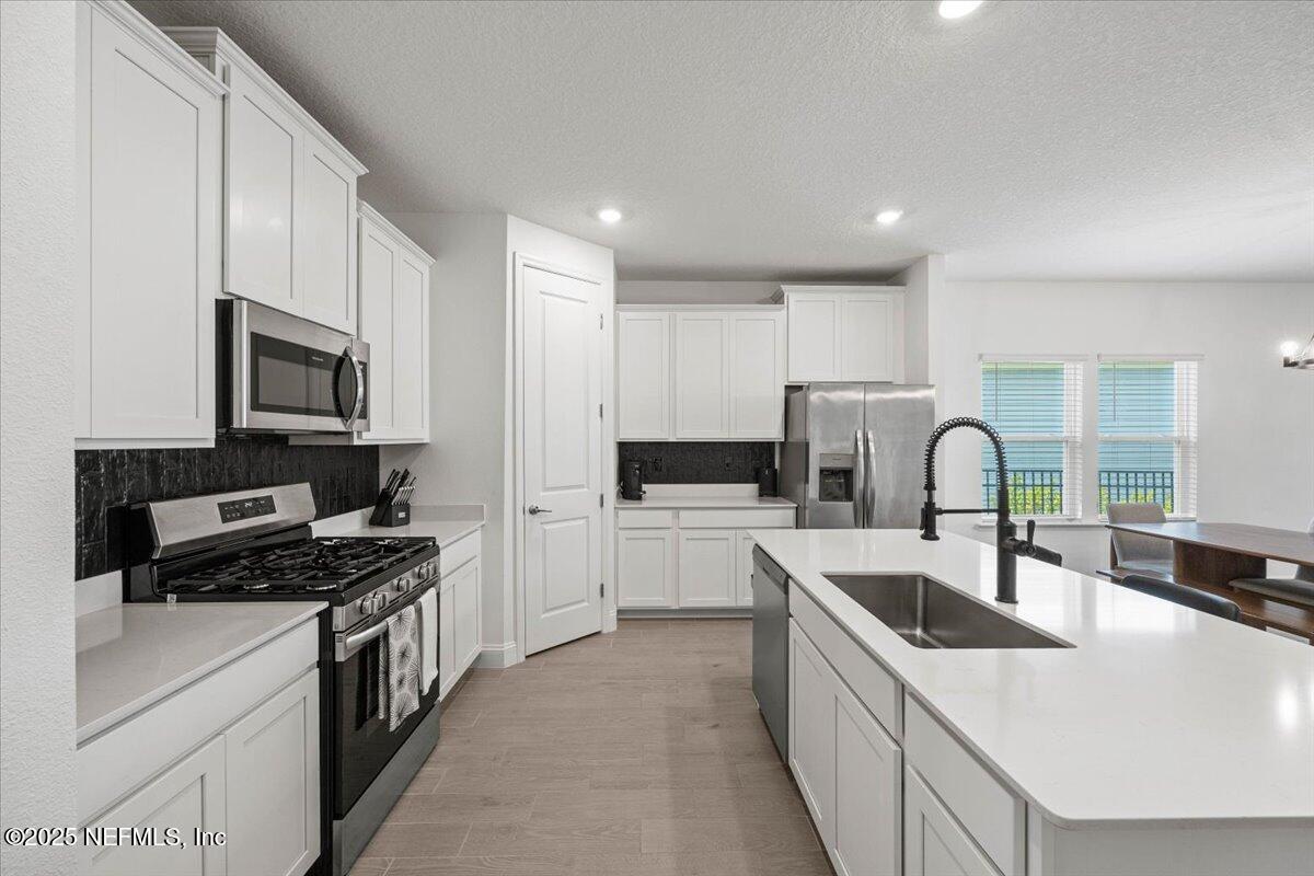 50 Dollar Court St. Augustine, FL 32092 - Photo 11 of 55 a kitchen with kitchen island a sink appliances and cabinets