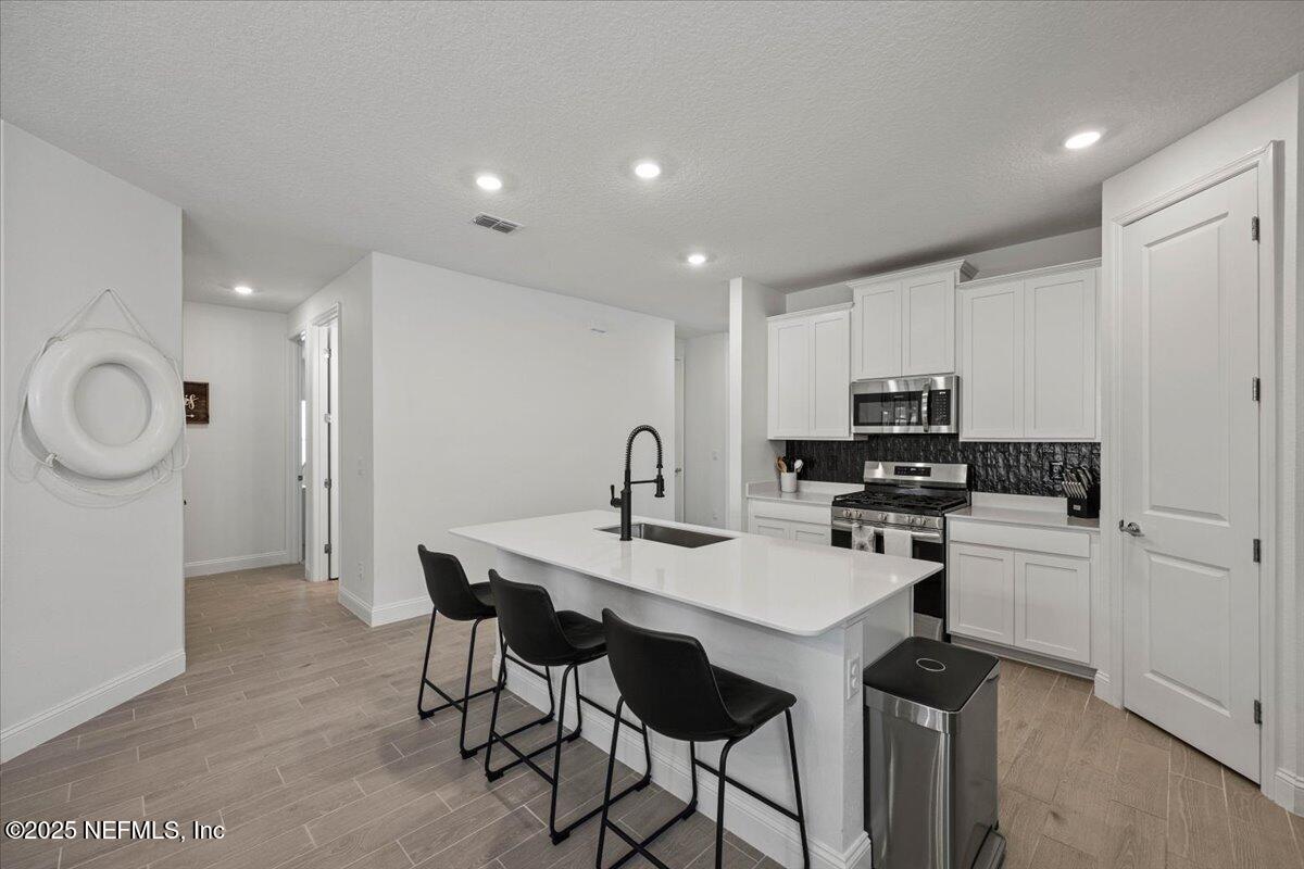 50 Dollar Court St. Augustine, FL 32092 - Photo 13 of 55 a kitchen with stainless steel appliances a table and chairs in it
