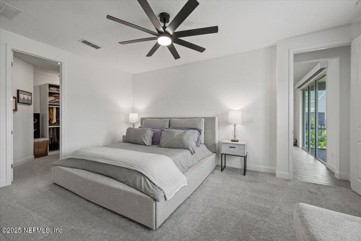 50 Dollar Court St. Augustine, FL 32092 - Photo 22 of 55 a spacious bedroom with a bed and a chandelier