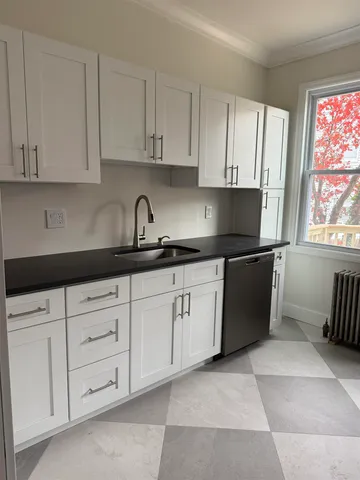 a kitchen with granite countertop white cabinets and sink