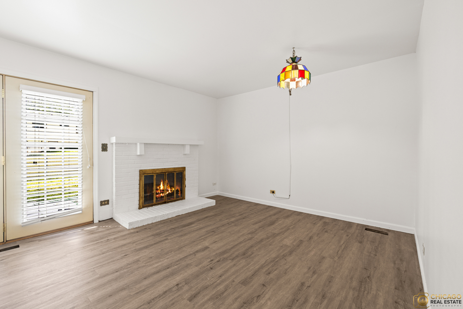 142 Cloverleaf Road Matteson, IL 60443 - Photo 6 of 22 an empty room with a fireplace and wooden floor