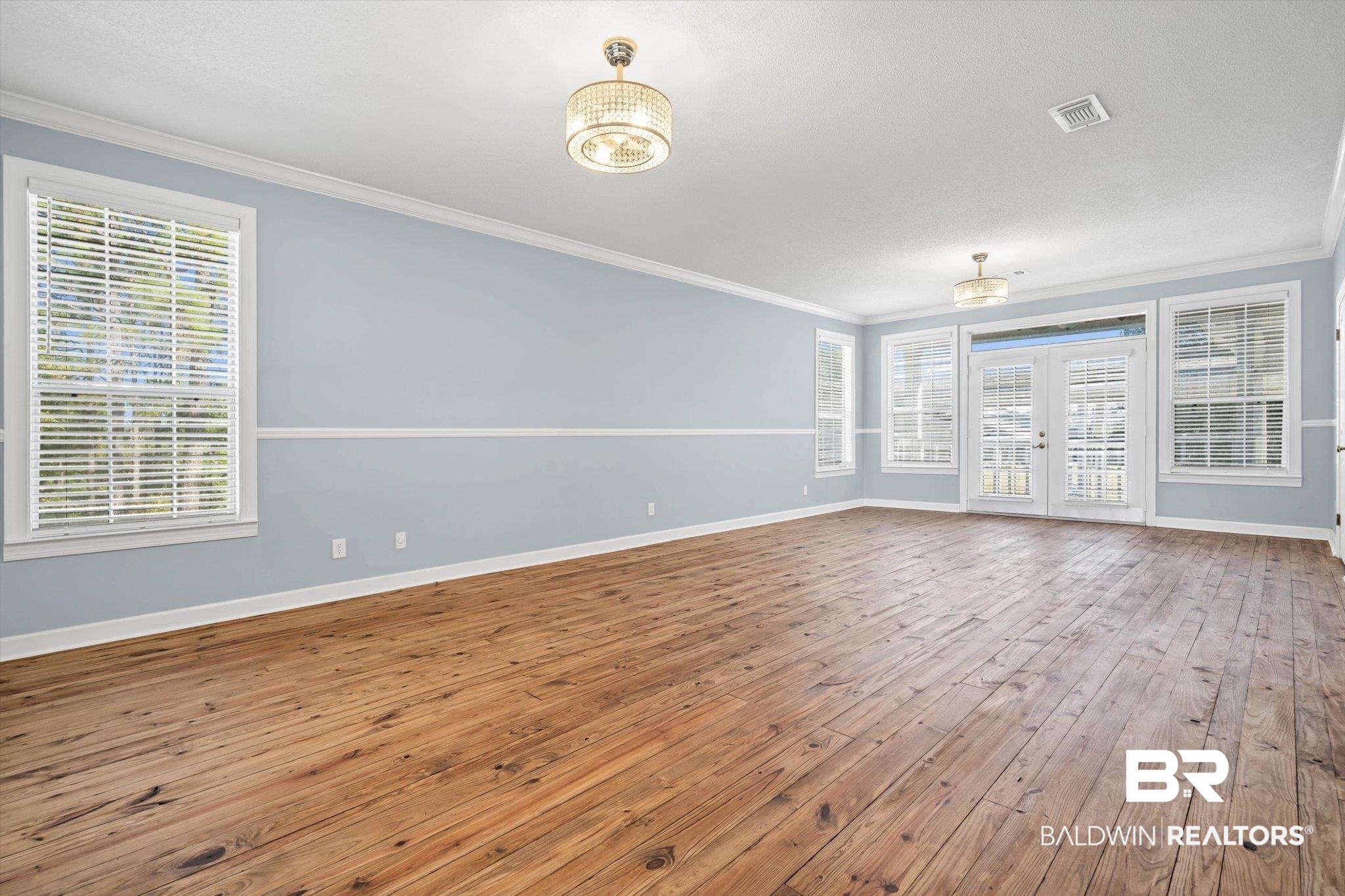 7650 Iron Rush Road Wilmer, AL 36587 - Photo 20 of 34 Unfurnished room with crown molding, french doors, and wood-type flooring