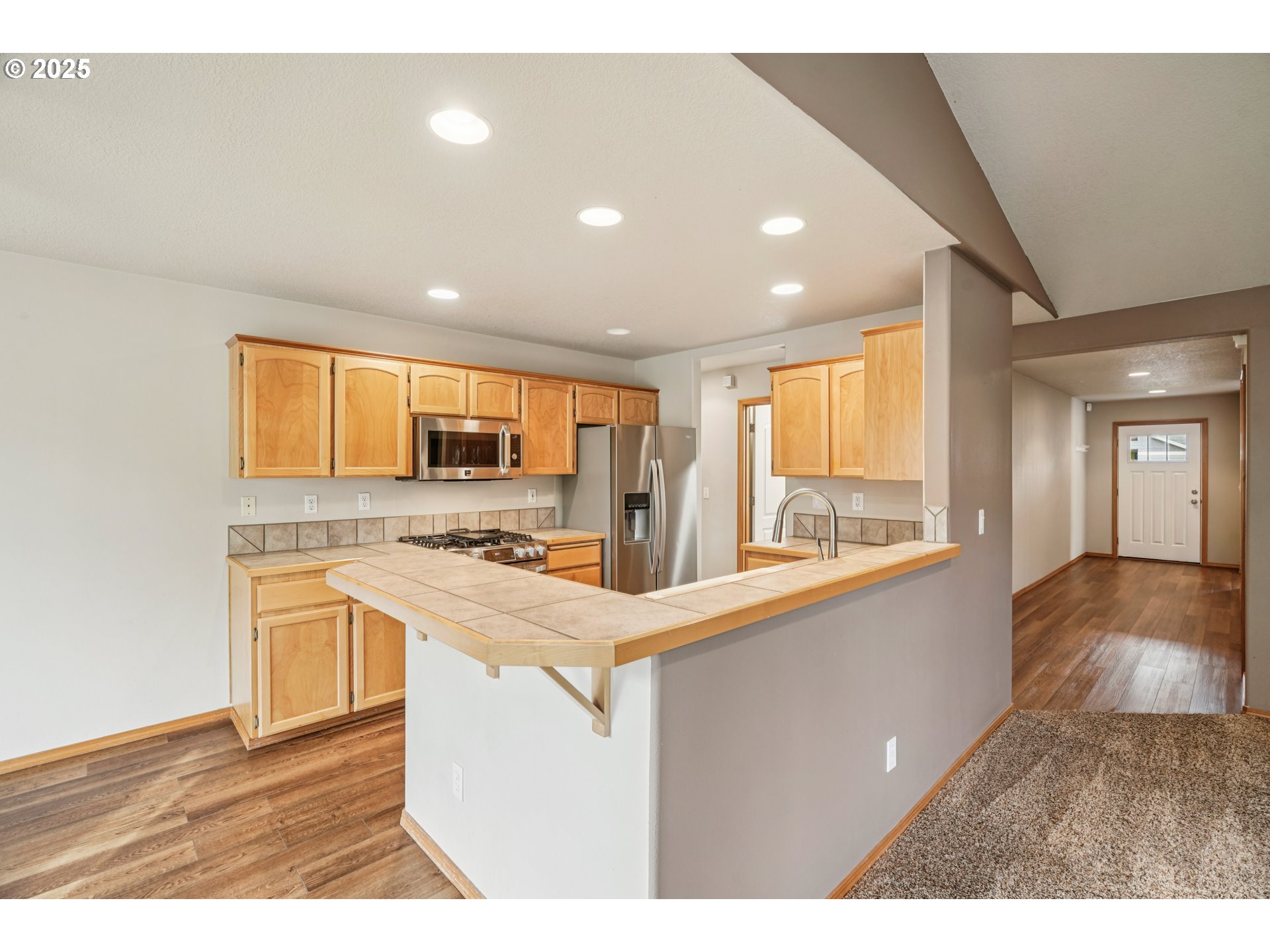 2892 Southeast Rosefinch Place Gresham, OR 97080 - Photo 12 of 37 a kitchen with stainless steel appliances granite countertop a stove and a refrigerator