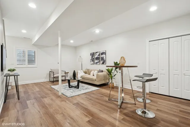 a living room with furniture a window and wooden floor