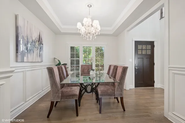 a view of a dining room with furniture a chandelier and wooden floor