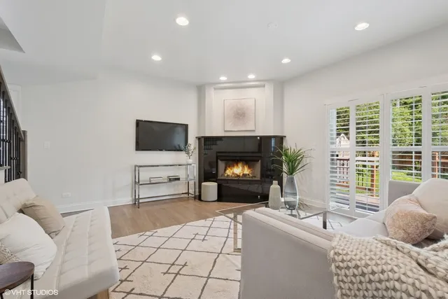 a living room with furniture a flat screen tv and a fireplace